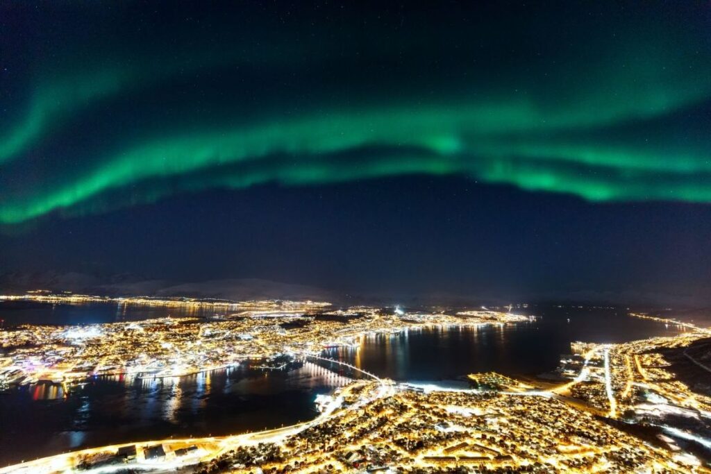 The best place to watch northern lights without taking a guided tour in Tromso, Norway is from the top station of the Fjellheisen cable car